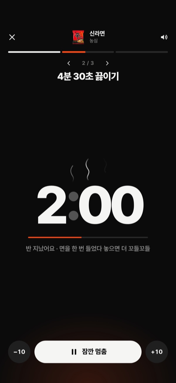 Cooking Shin Ramyun: a large 2:00 with steam rising above it, and below, a line saying it’s halfway and to lift the noodles once for a chewier bite